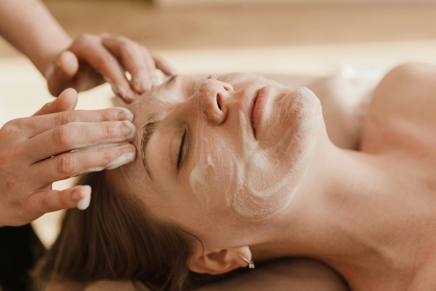 A relaxed client receiving a cleansing facial ritual